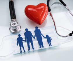 Family of four silhouette in blue on mask with stethoscope and red heart